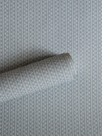 Zigzag wallpaper by Långelid/von Brömssen in Blue – geometric design, a part-rolled length showing the woven zigzag