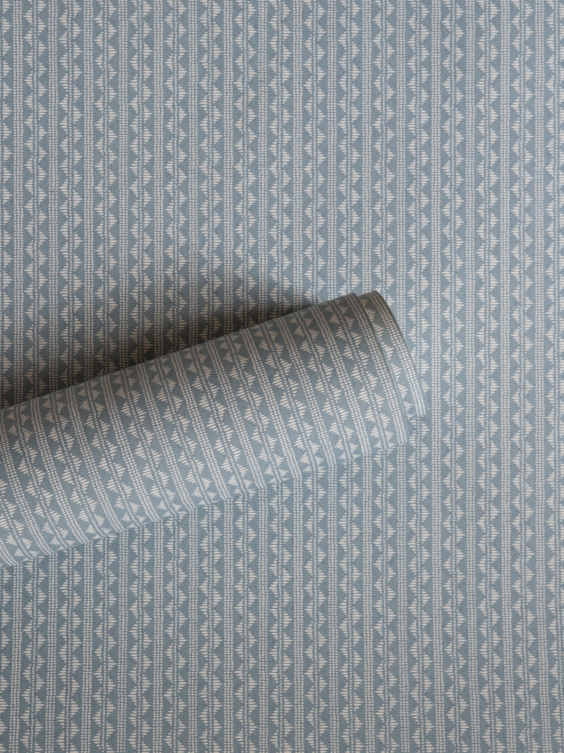 Zigzag wallpaper by Långelid/von Brömssen in Blue – geometric design, a part-rolled length showing the woven zigzag