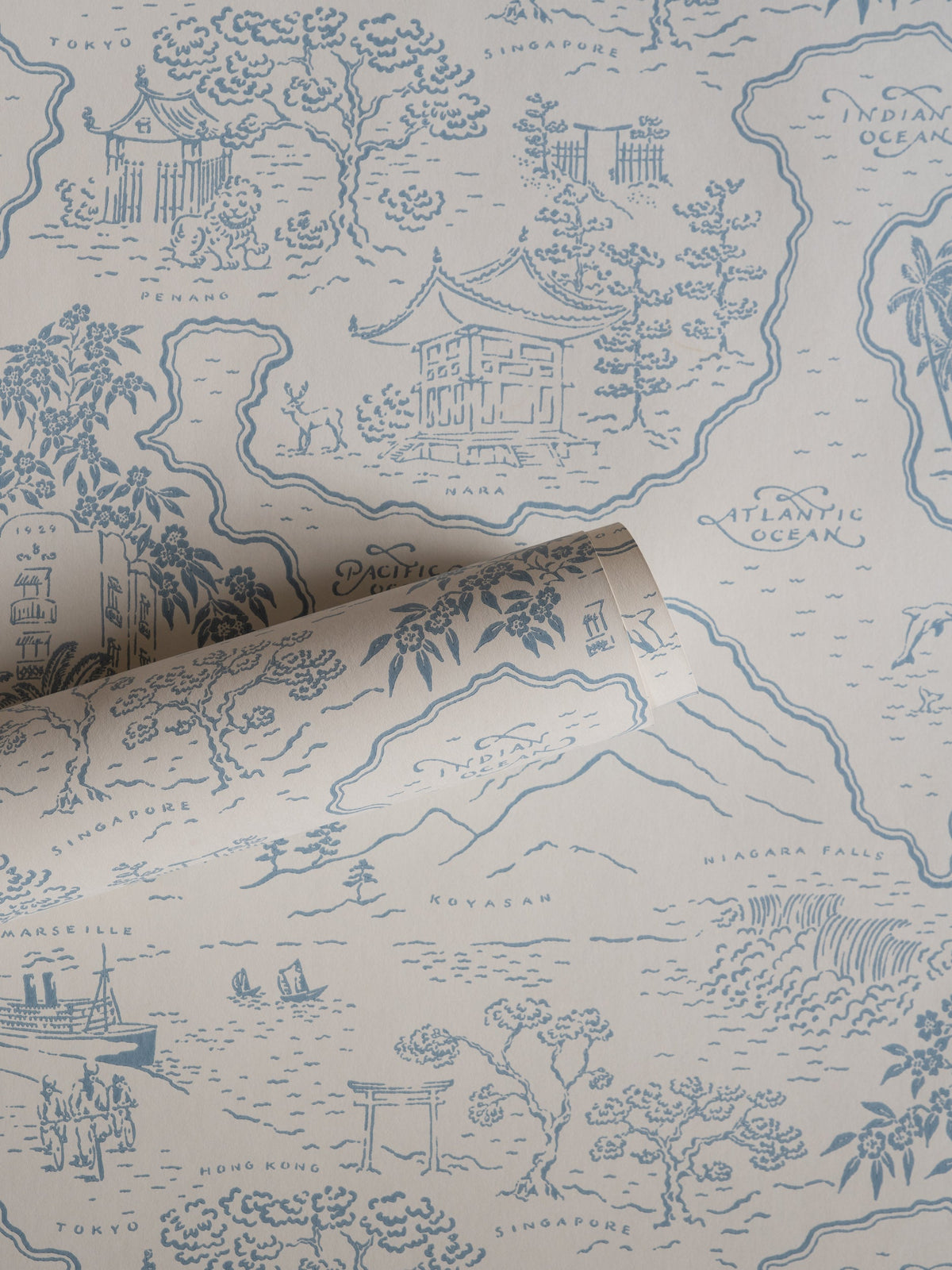 Voyage 1929 wallpaper by Långelid/von Brömssen in Blue – coastal design, a part-rolled length showing the map motif