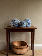 Zigzag wallpaper by Långelid/von Brömssen in Beige – geometric design, behind a wooden table with blue and white ginger jars