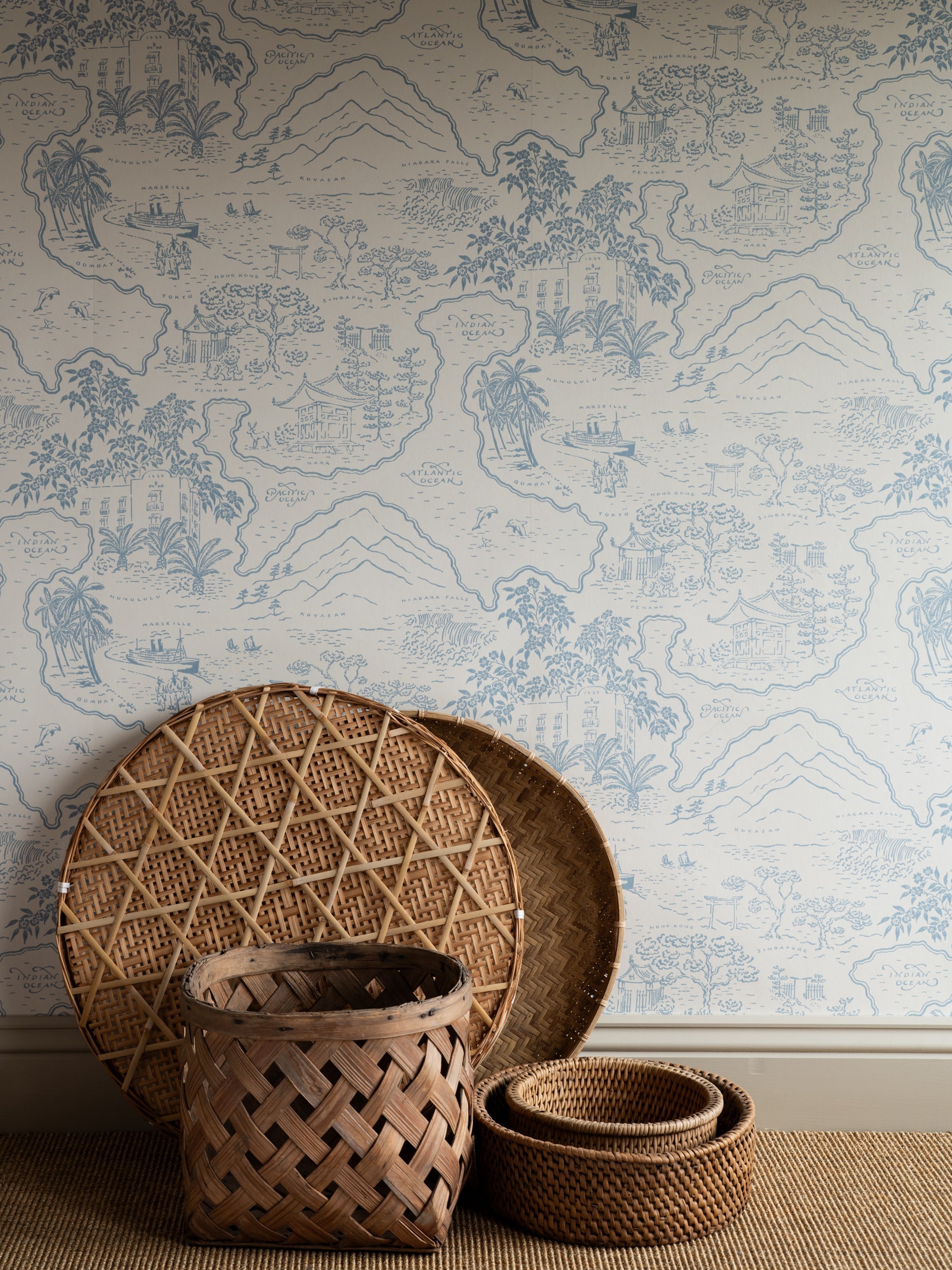 Voyage 1929 wallpaper by Långelid/von Brömssen in Blue – coastal design, with woven baskets and a rattan tray