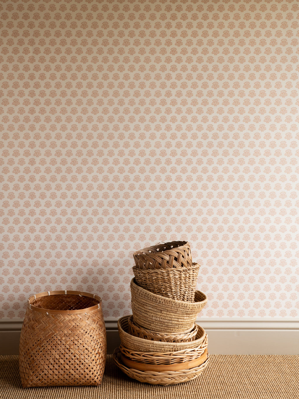 India wallpaper by Långelid/von Brömssen in Peach – floral design, with a stack of woven baskets