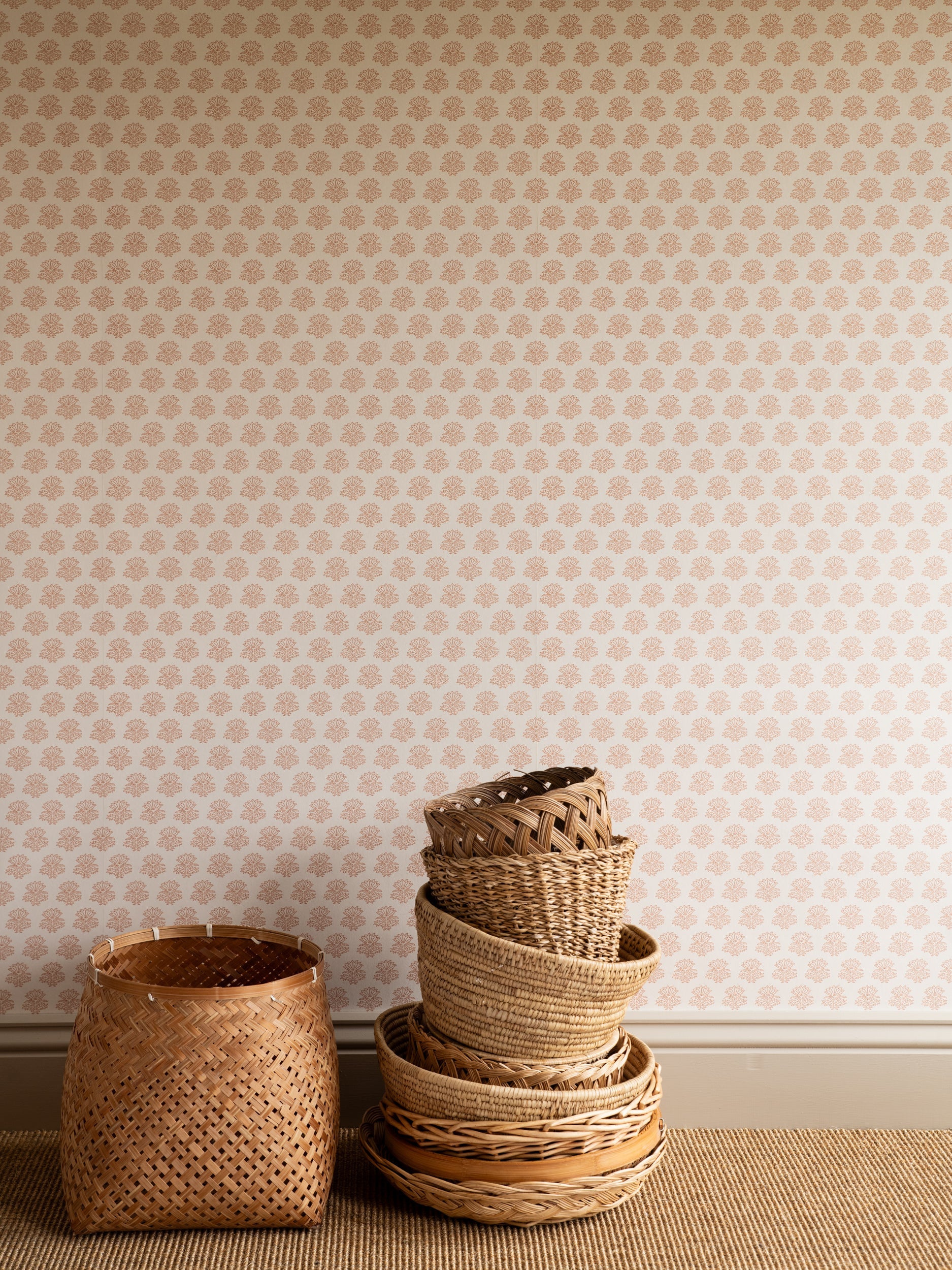 India wallpaper by Långelid/von Brömssen in Peach – floral design, with a stack of woven baskets