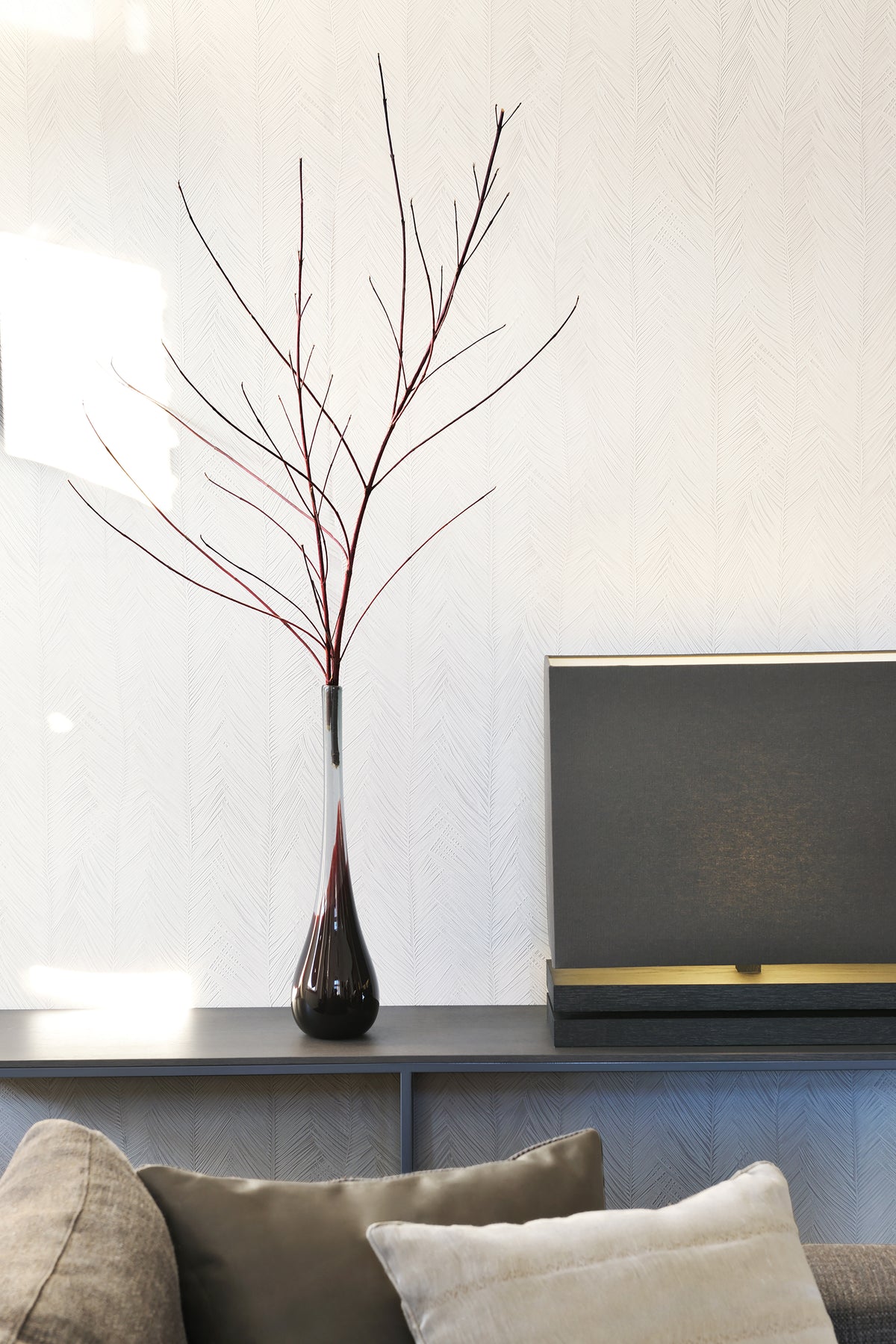 Itaya wallpaper by Arte in Cream behind a console with a branch in a tall vase