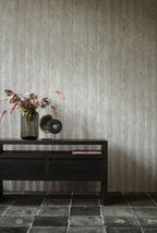 Itaya wallpaper by Arte in Grey behind a black console with a vase of flowers