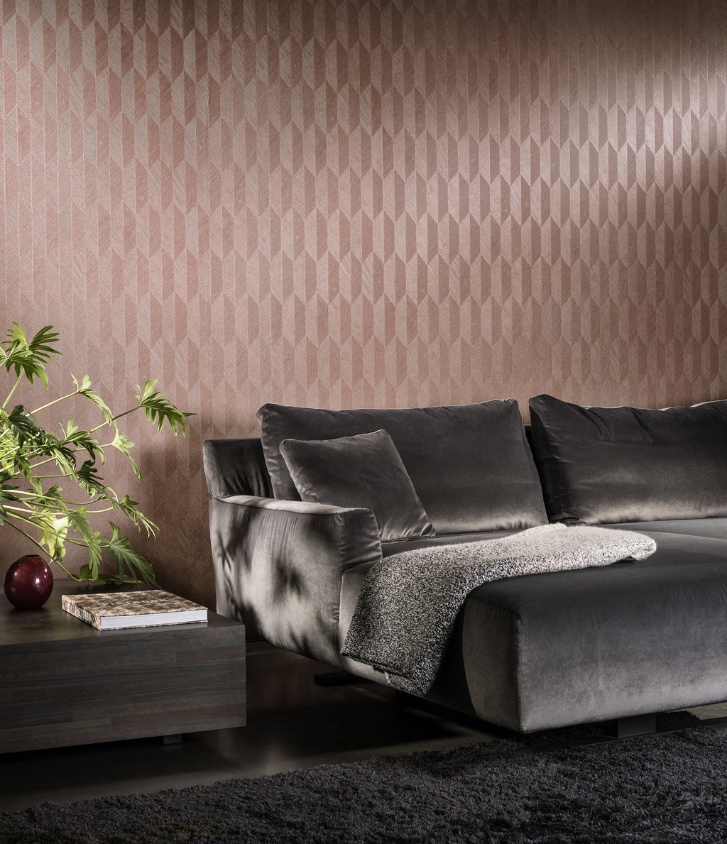 Symbol wallpaper by Arte in Pink behind a grey velvet sofa