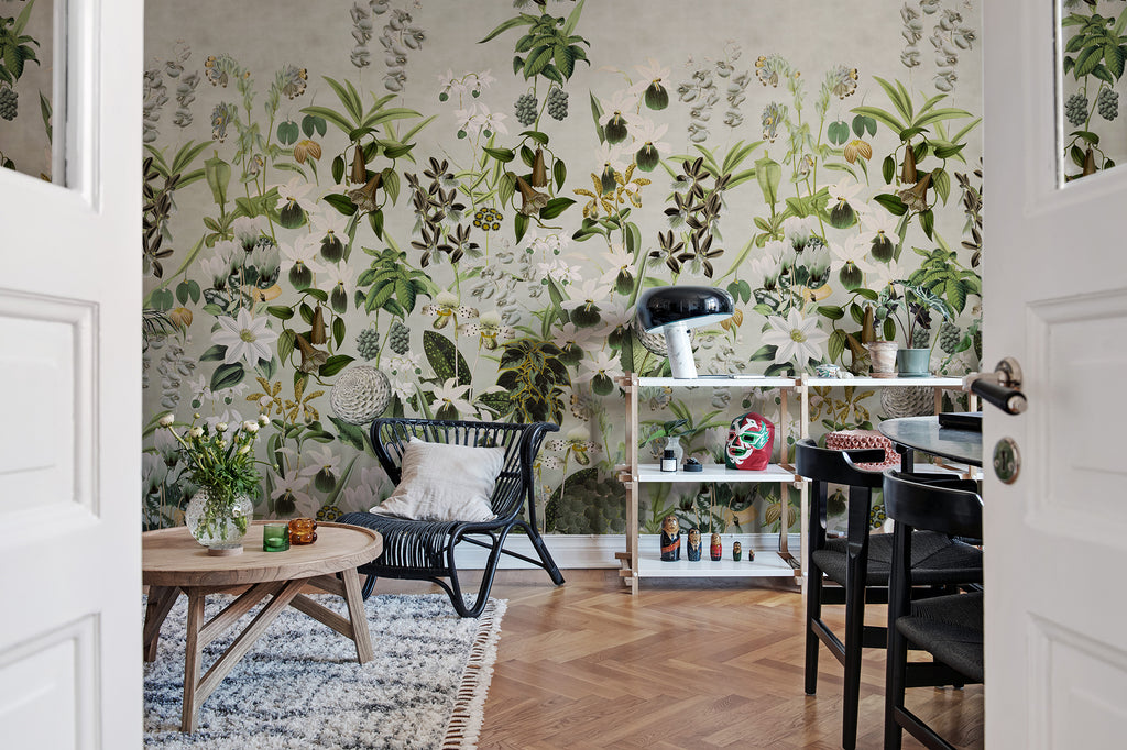 Alice's Garden Mural by Rebel Walls in green sage colourway styled in a dining room with rattan chair