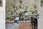Alice's Garden Mural by Rebel Walls in green sage colourway styled in a dining room with rattan chair