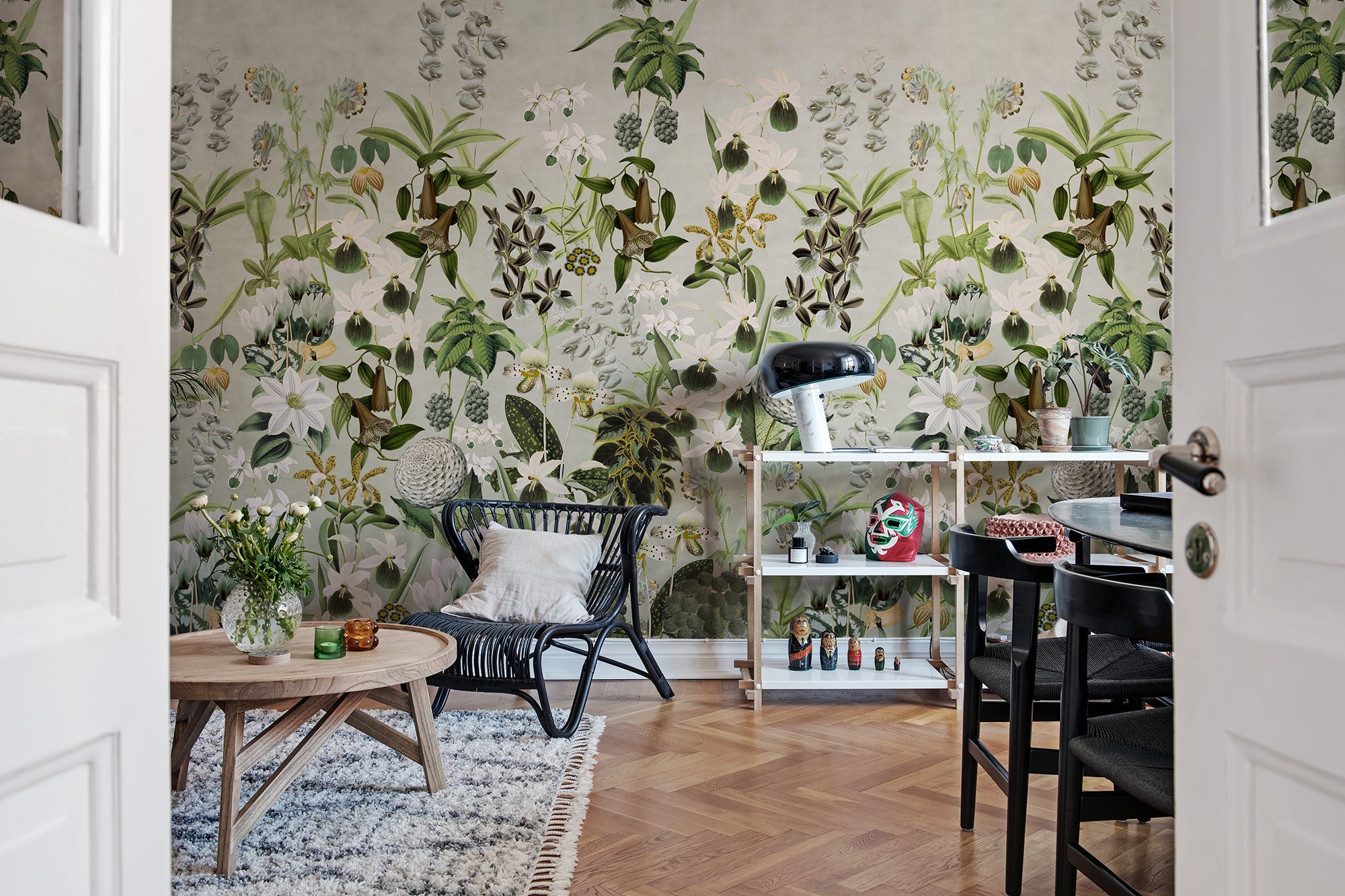 Alice's Garden Mural by Rebel Walls in green sage colourway styled in a dining room with rattan chair