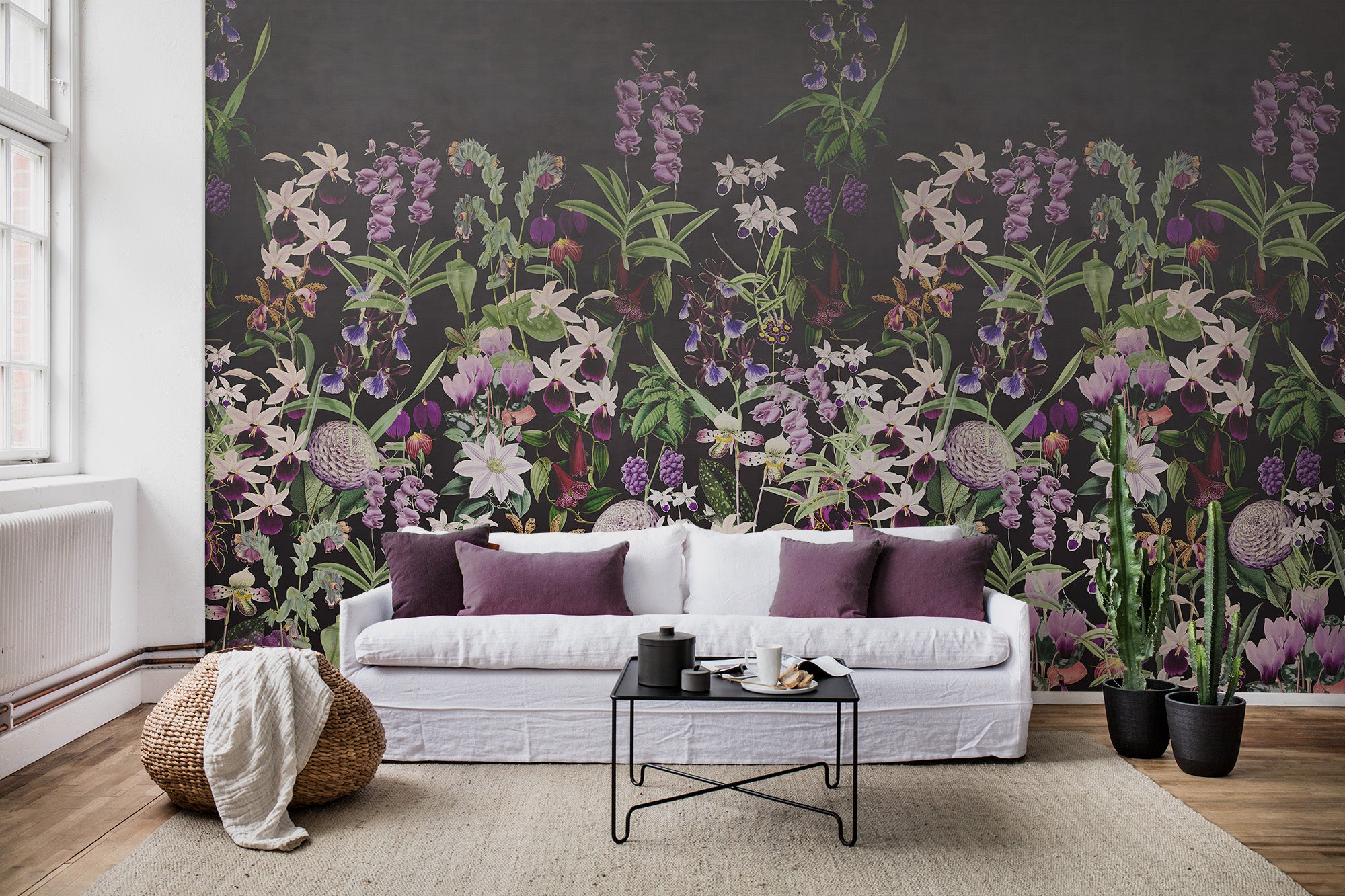 Alice's Garden Mural by Rebel Walls in dramatic dark colourway behind a white sofa with purple cushions