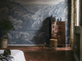 Mystery Lake wall mural by Rebel Walls in dusty blue, engraved valley and lake styled behind a wooden cabinet and ginger jars