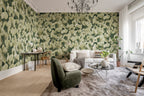 Corals wall mural by Rebel Walls in sage green, in a bright living room with green armchair and white sofa