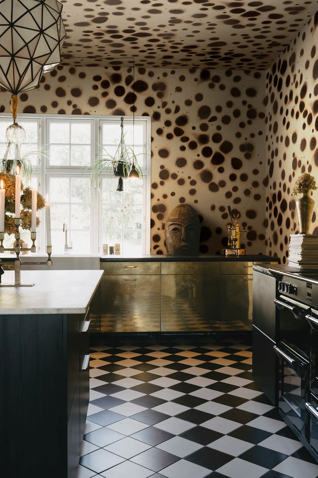 Spotted Puffer wall mural by Rebel Walls, dark brown spots on cream covering walls and ceiling of a brass-cabinet kitchen
