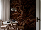 Guppy wall mural by Rebel Walls in rich chocolate brown watercolour swirls, behind a dining table with pendant light
