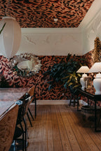 Discus Fish wall mural by Rebel Walls in red and rust marbled swirls on walls and ceiling of a styled dining room