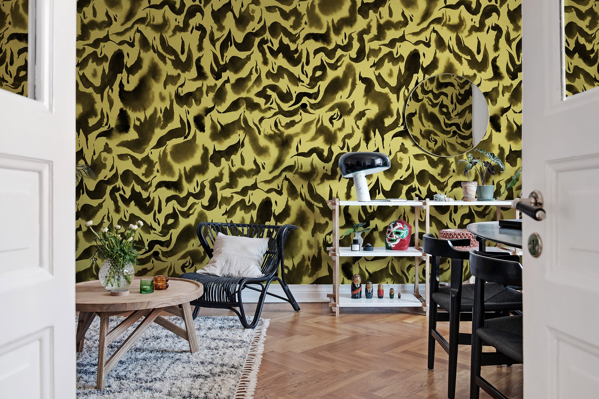 Discus Fish wall mural by Rebel Walls in olive yellow and black swirls, in a room with rattan chair and round timber table