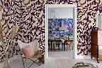 Discus Fish wall mural by Rebel Walls in plum purple and cream swirls, in an entry with butterfly chair by a doorway