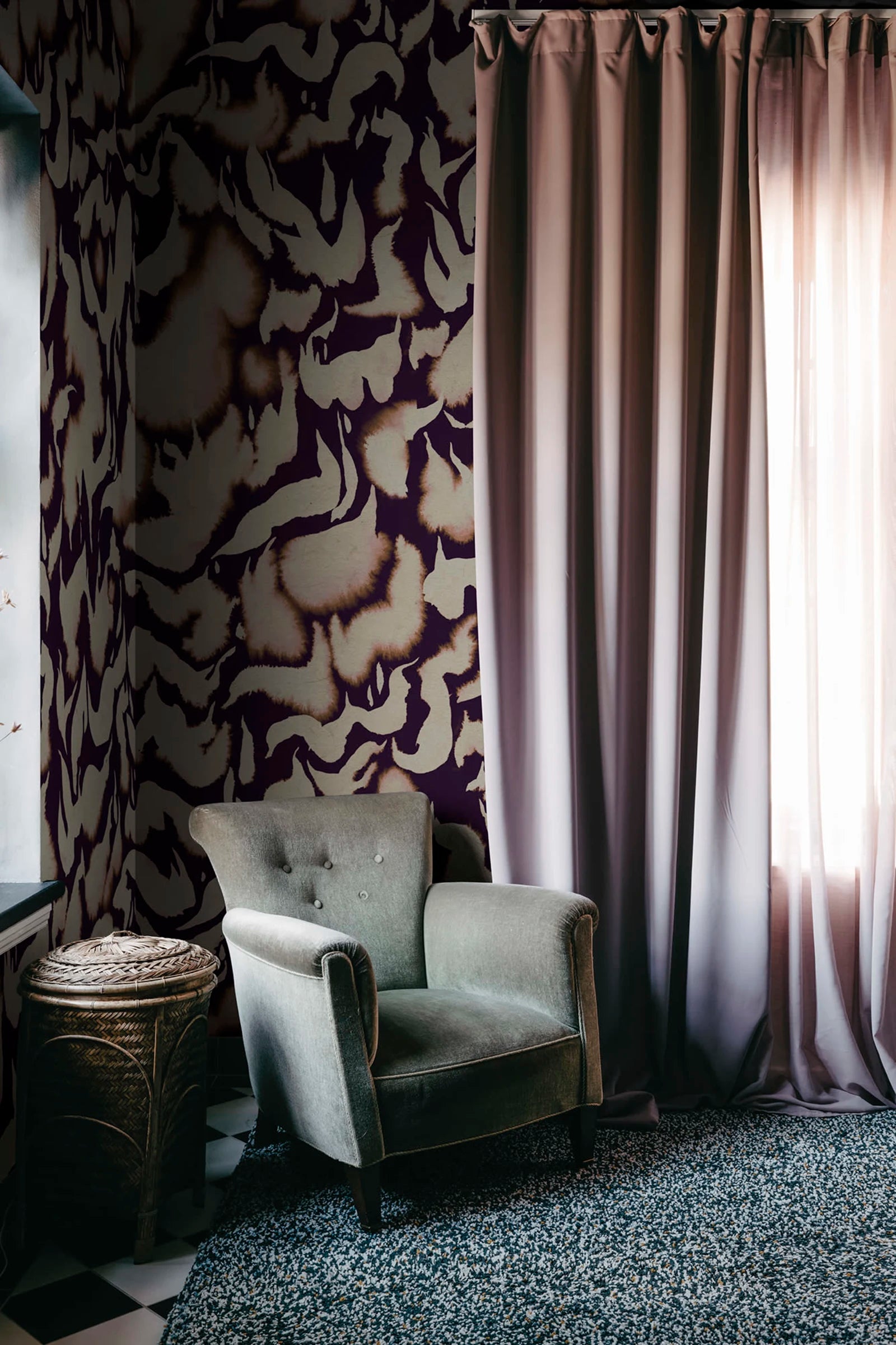 Discus Fish wall mural by Rebel Walls in plum and cream swirls, beside long curtains and a grey velvet armchair
