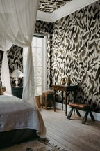 Discus Fish wall mural by Rebel Walls in black and cream swirls, behind a canopy bed with antique writing desk