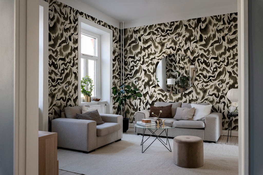 Discus Fish wall mural by Rebel Walls in black and cream swirls, in a neutral living room with grey armchairs