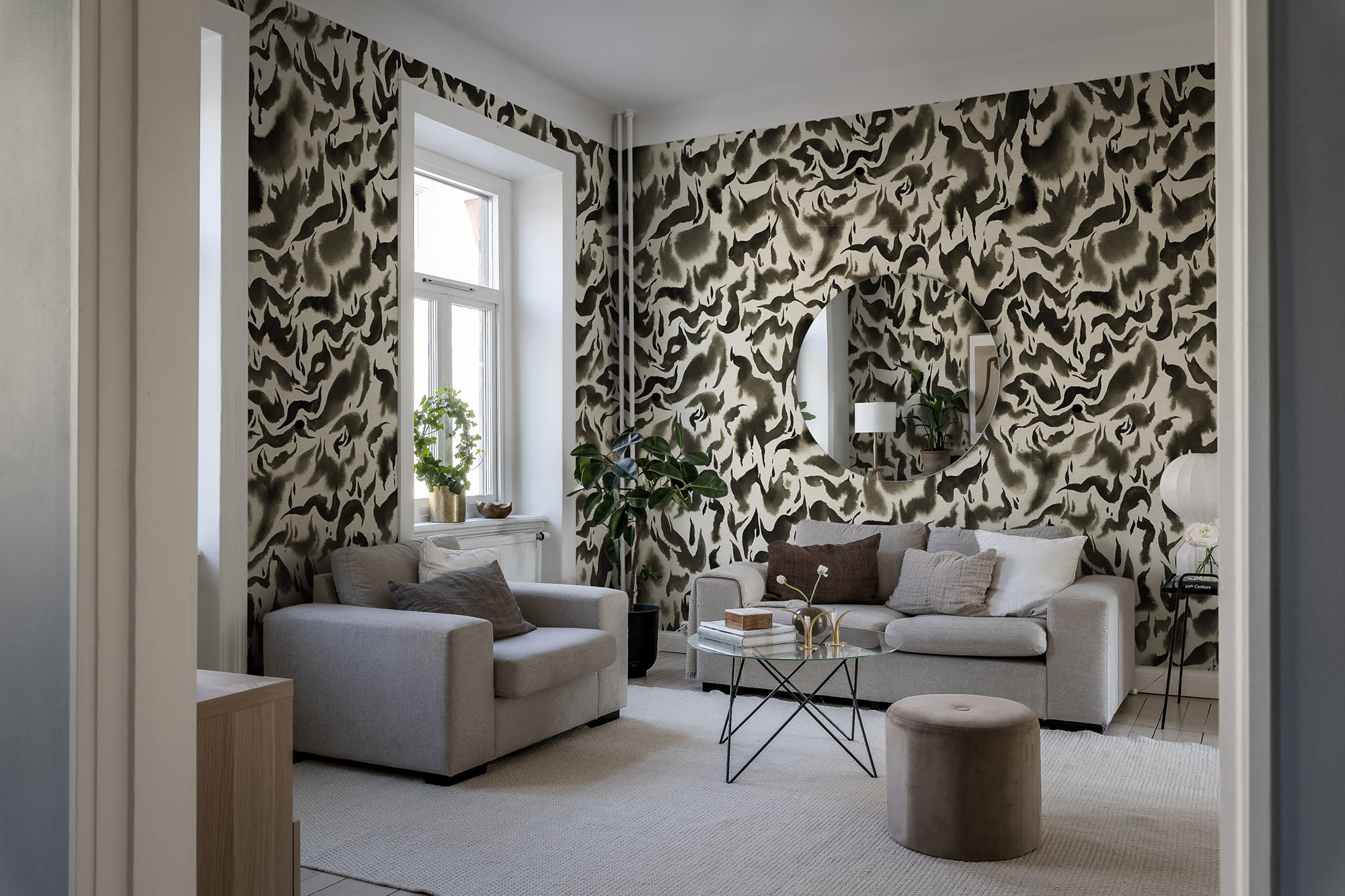 Discus Fish wall mural by Rebel Walls in black and cream swirls, in a neutral living room with grey armchairs