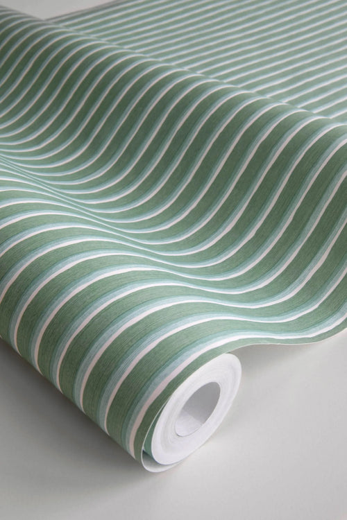 Brita Stripe wallpaper by Sandberg in green, close-up of a wallpaper roll showing fine painterly vertical stripes