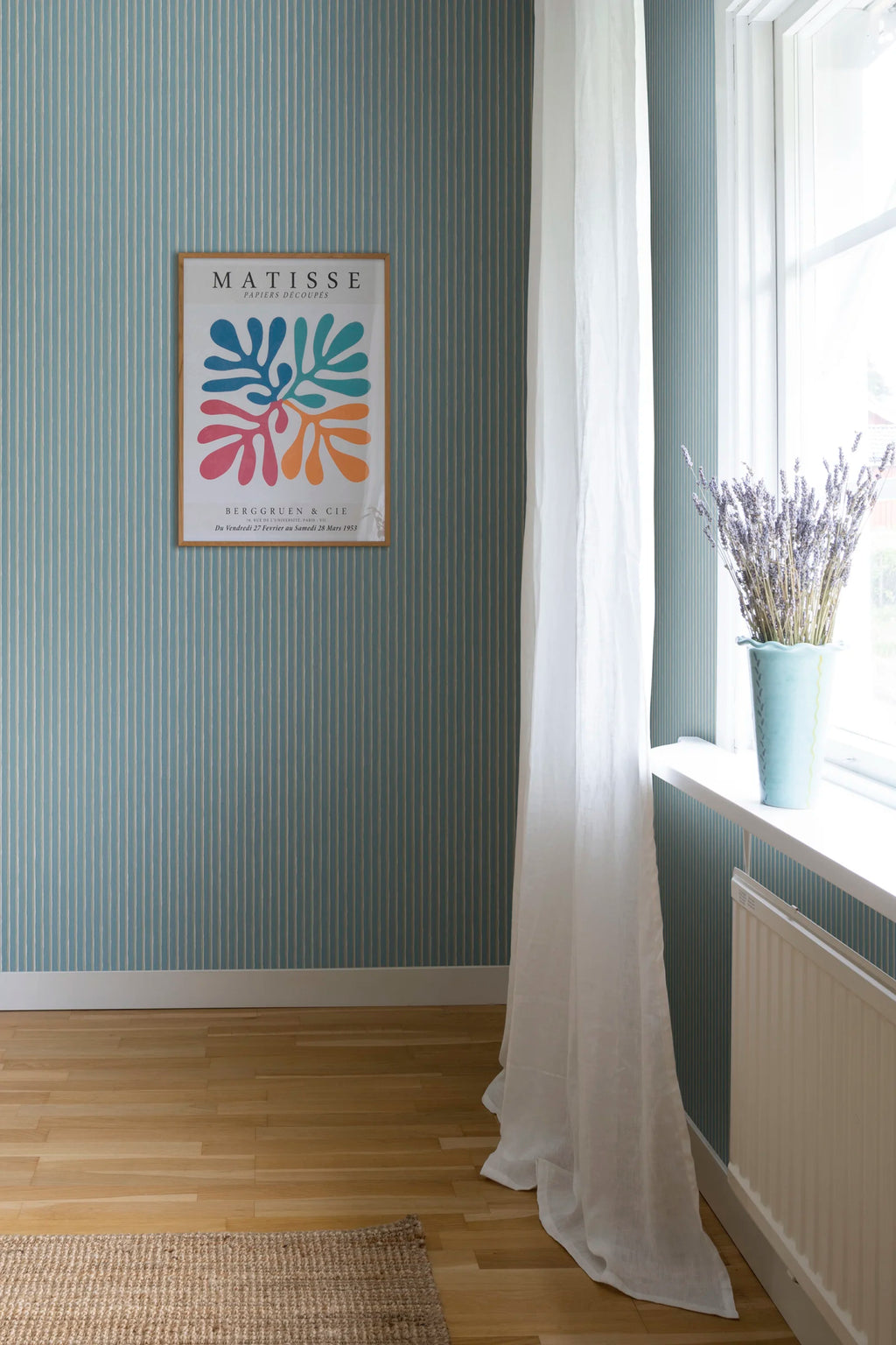 Brita Stripe wallpaper by Sandberg in soft blue, styled in a sunny room with Matisse print, white curtain and lavender