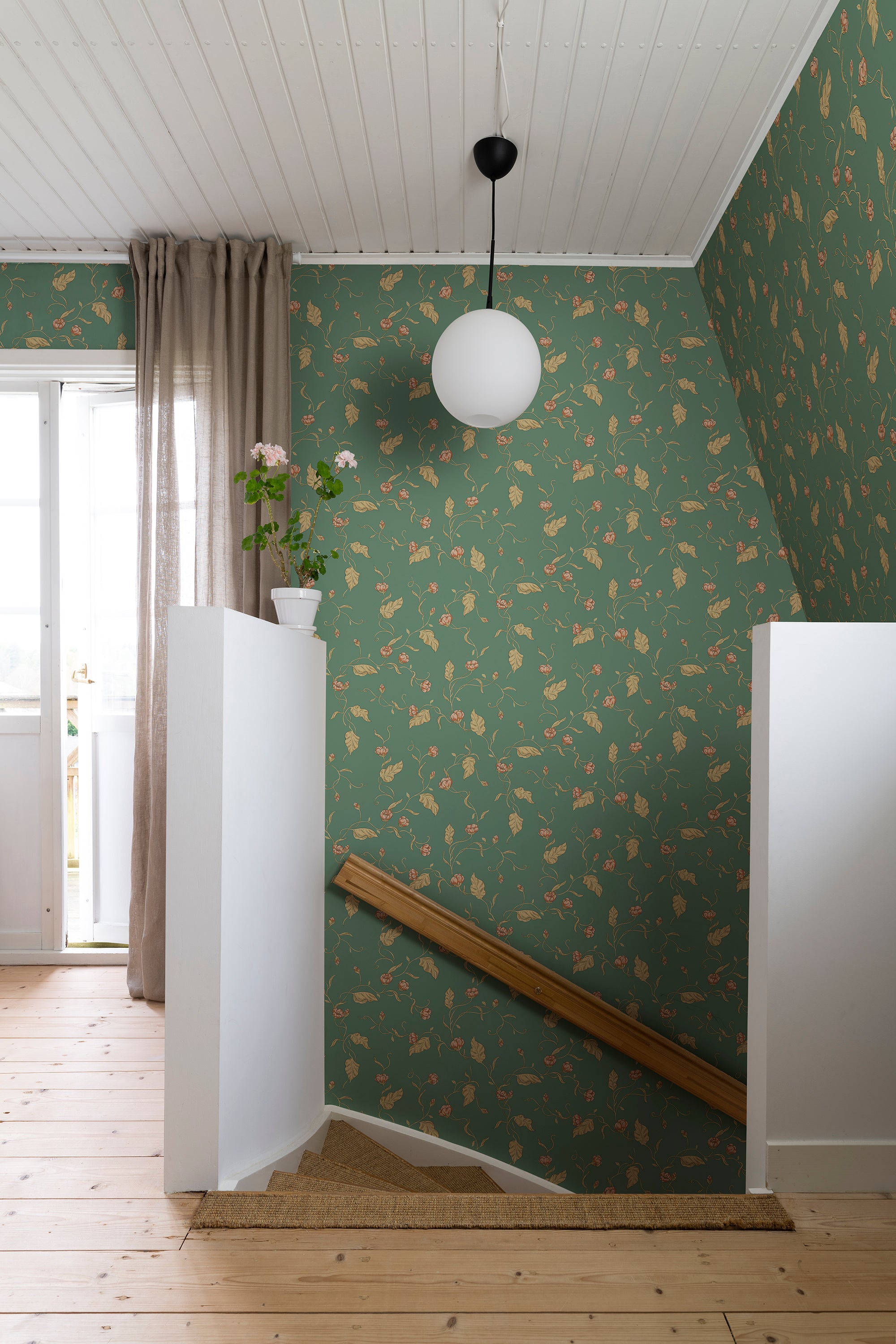 Elmire wallpaper by Sandberg in green on a stairwell landing with a globe pendant light and pine floor