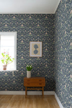 Till Carl wallpaper by Sandberg in navy, styled in a room corner with teak chest and framed art
