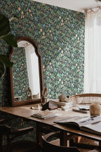 Huset i Solen wallpaper by Sandberg in dark meadow print styled behind a wooden desk with an arched mirror and sheer curtain
