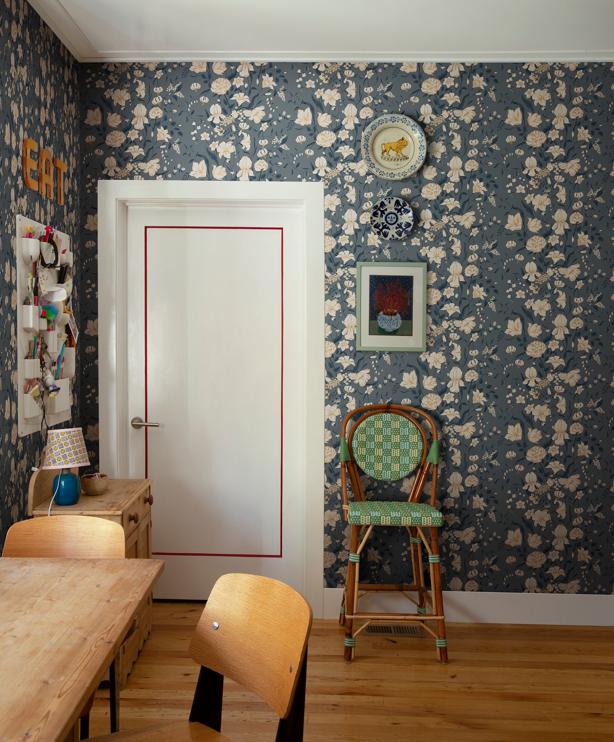 Karins Bukett wallpaper by Sandberg in slate blue in a dining nook with a rattan chair and timber table