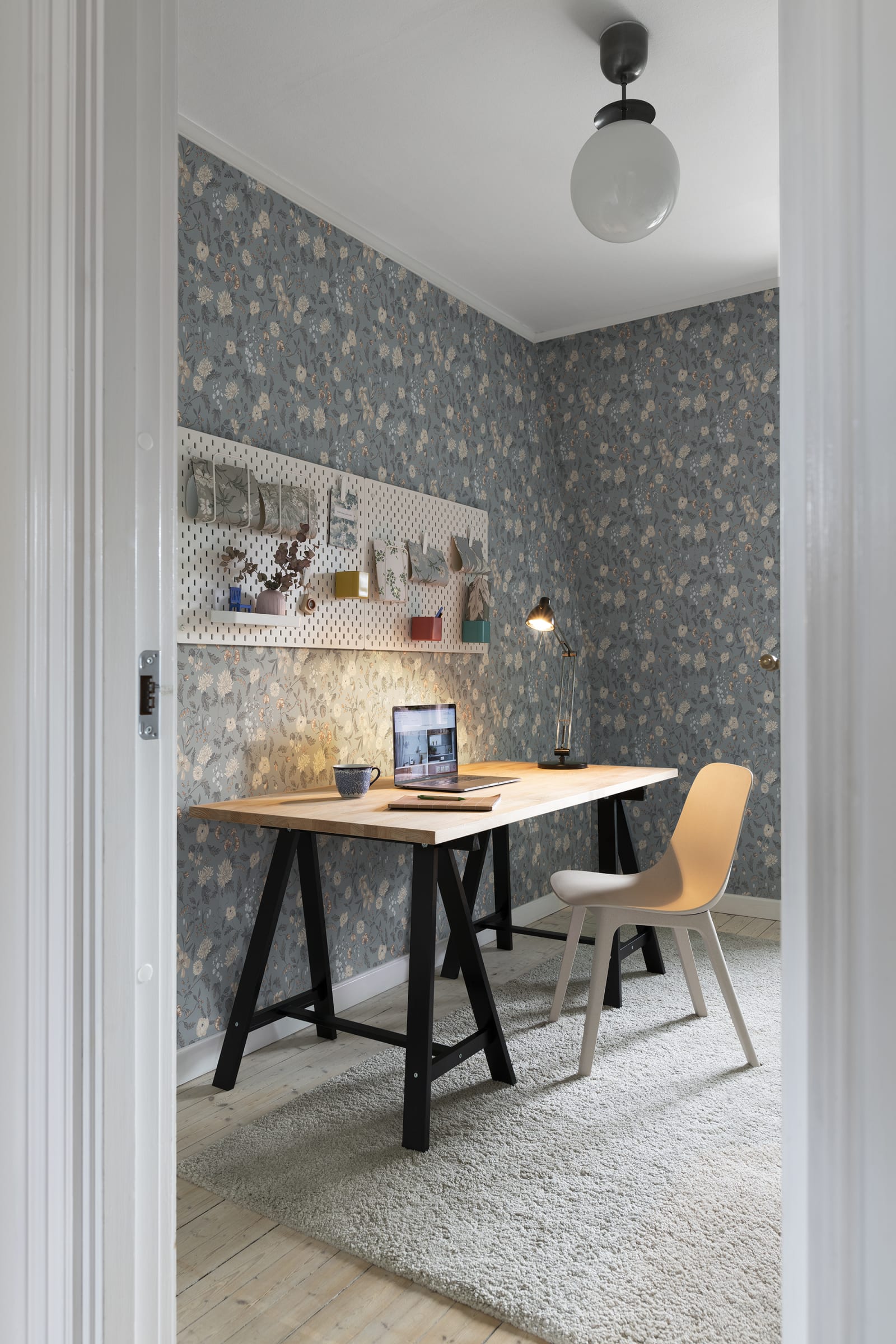 Till Karin wallpaper by Sandberg in dusty blue floral in a small home office with trestle desk and pegboard