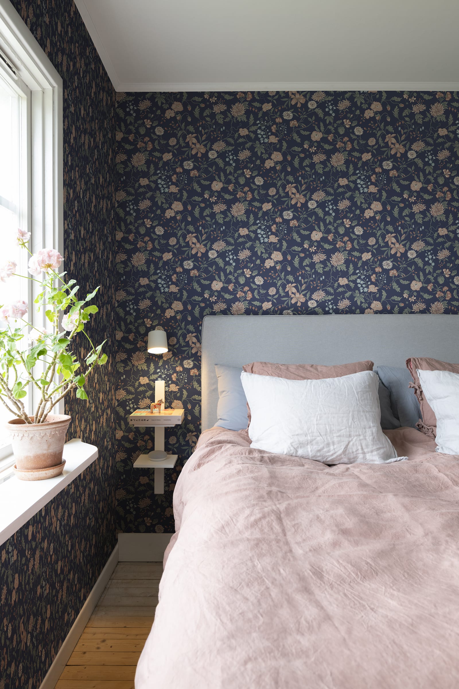 Till Karin wallpaper by Sandberg in navy floral behind a bed with grey headboard and dusty pink linen bedding