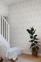 Emma wallpaper by Sandberg in soft beige with lupins and poppies in a stairwell with sheepskin chair and rubber plant