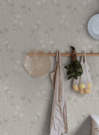 Emma wallpaper by Sandberg in pale grey-green on a wall with peg rail holding an apron and net bag of lemons