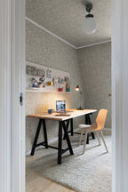 Olof wallpaper by Sandberg in muted green styled in a home office with a trestle desk, laptop and pale chair