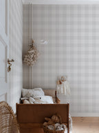 Lykke wallpaper by Sandberg in soft grey check styled in a nursery with a timber cot, dried flowers and a tiny dress