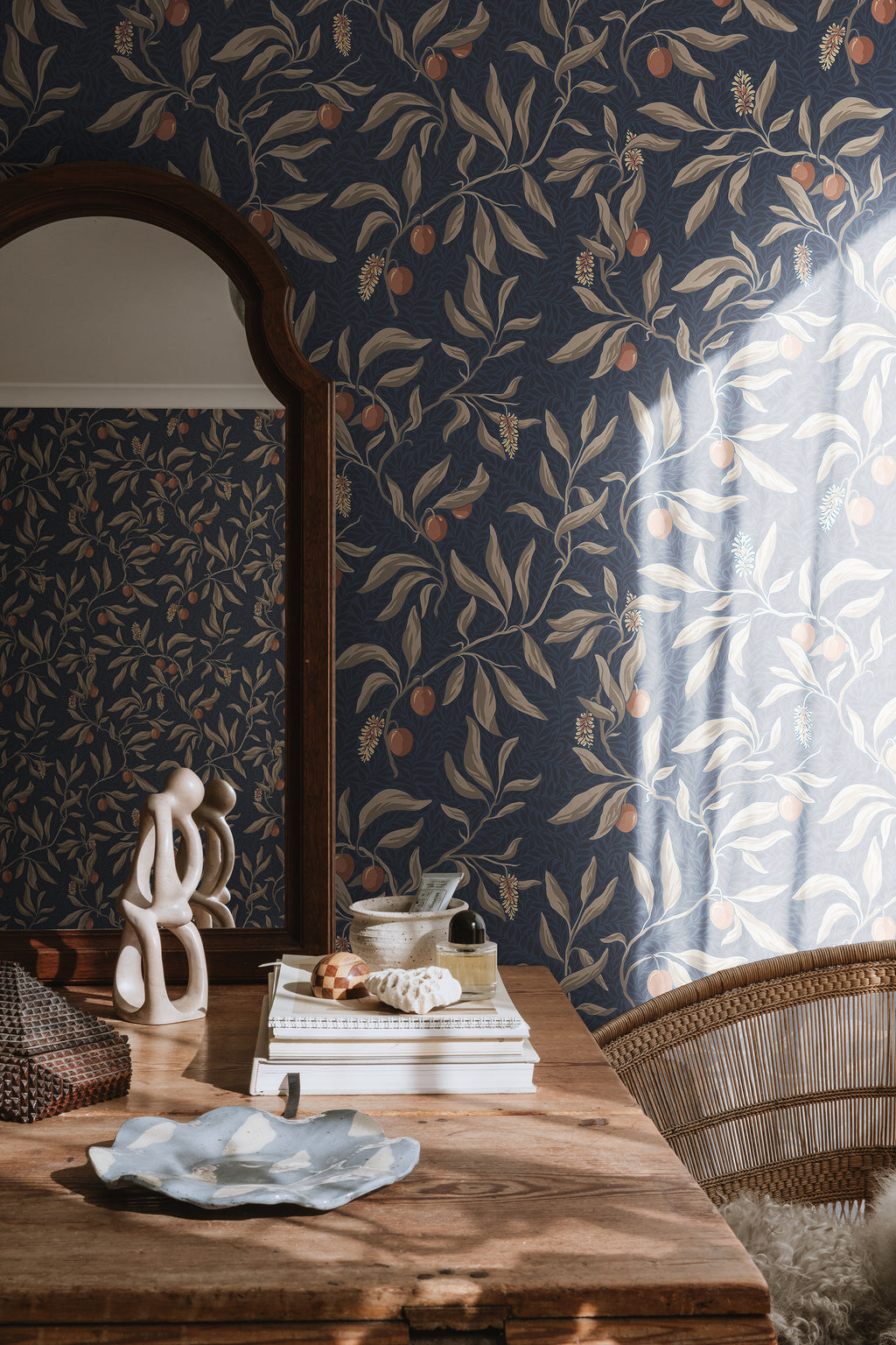 Navy Vinnie wallpaper by Sandberg behind an arched mirror and styled wooden dressing table