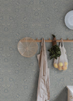 Caroline wallpaper by Sandberg in slate blue in a hallway with a peg rail holding a linen apron and string bag of lemons