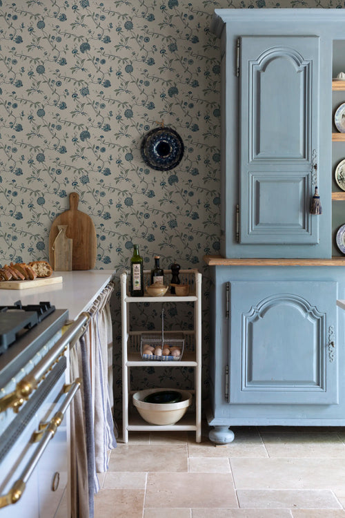 Adelaide wallpaper by Sandberg, close-up of blue floral vines on cream behind a kitchen shelf of bowls and eggs