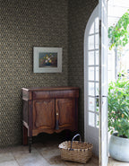 Turtledove Barn wallpaper by Sandberg in dark green styled in an entry with an antique timber cabinet, framed still life and arched door