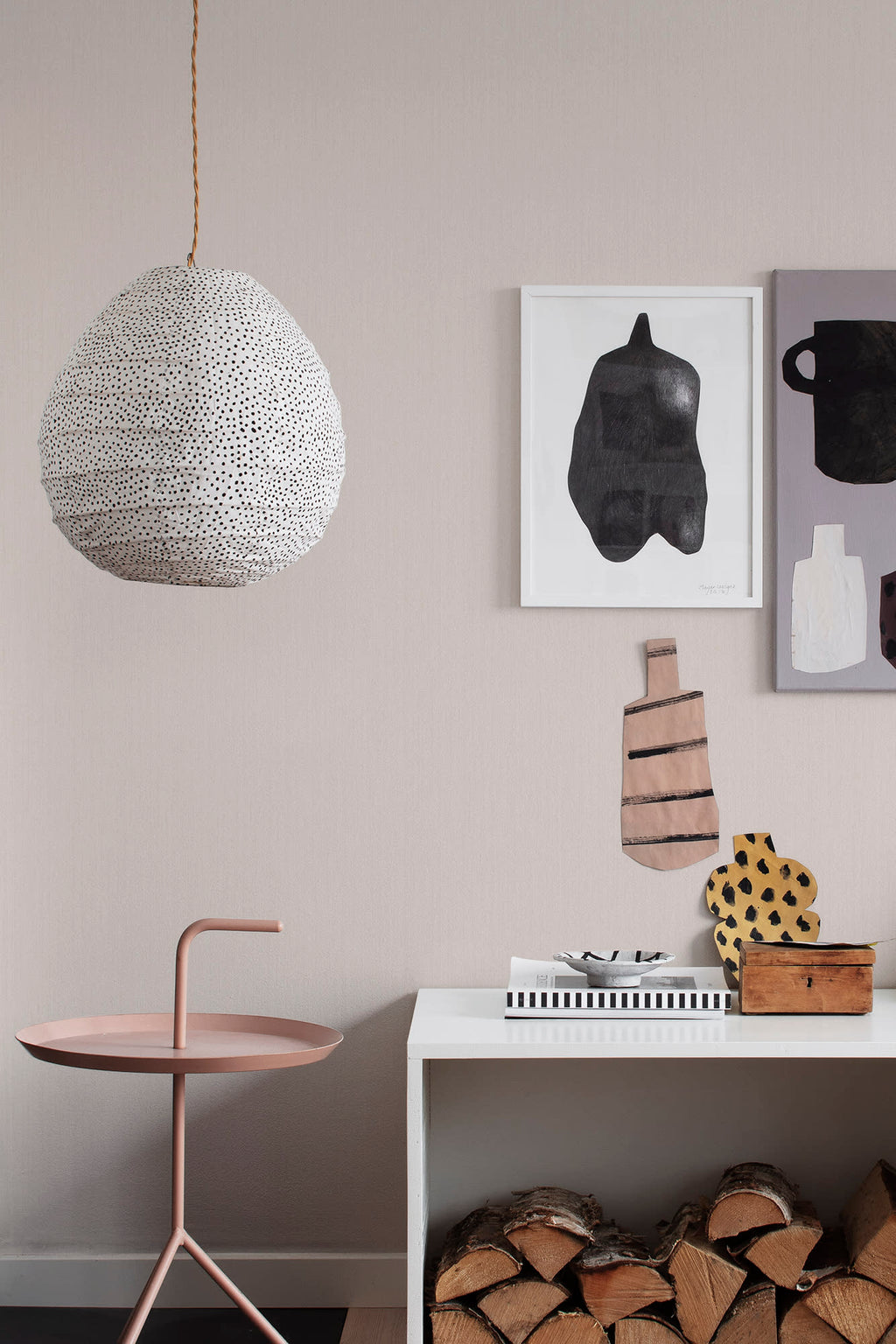 Linne wallpaper by Sandberg in blush pink styled in a living room with a spotted pendant light and art prints