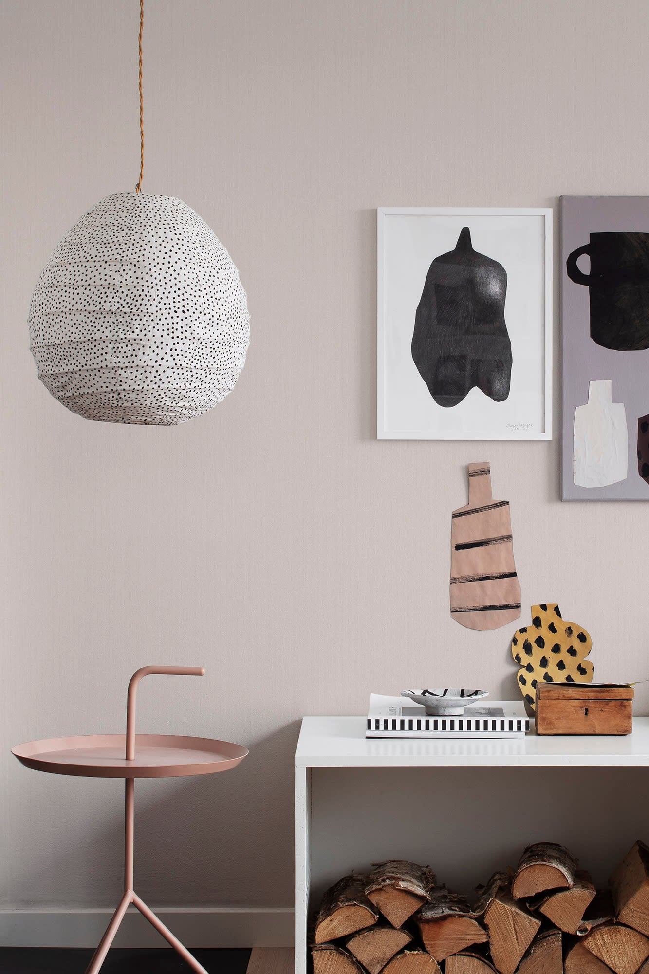Linne wallpaper by Sandberg in blush pink styled in a living room with a spotted pendant light and art prints