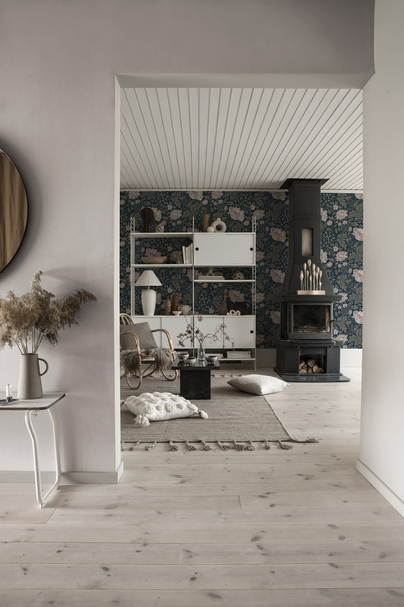 Linne wallpaper by Sandberg in pale tone glimpsed in a Scandinavian living room with a black fireplace