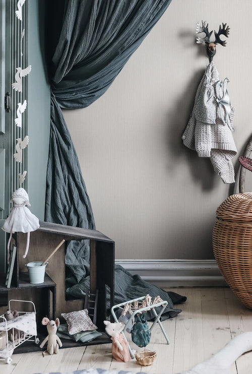 Rand Stripe wallpaper by Sandberg in warm greige, styled in a childs room with grey canopy, dolls house and woven basket