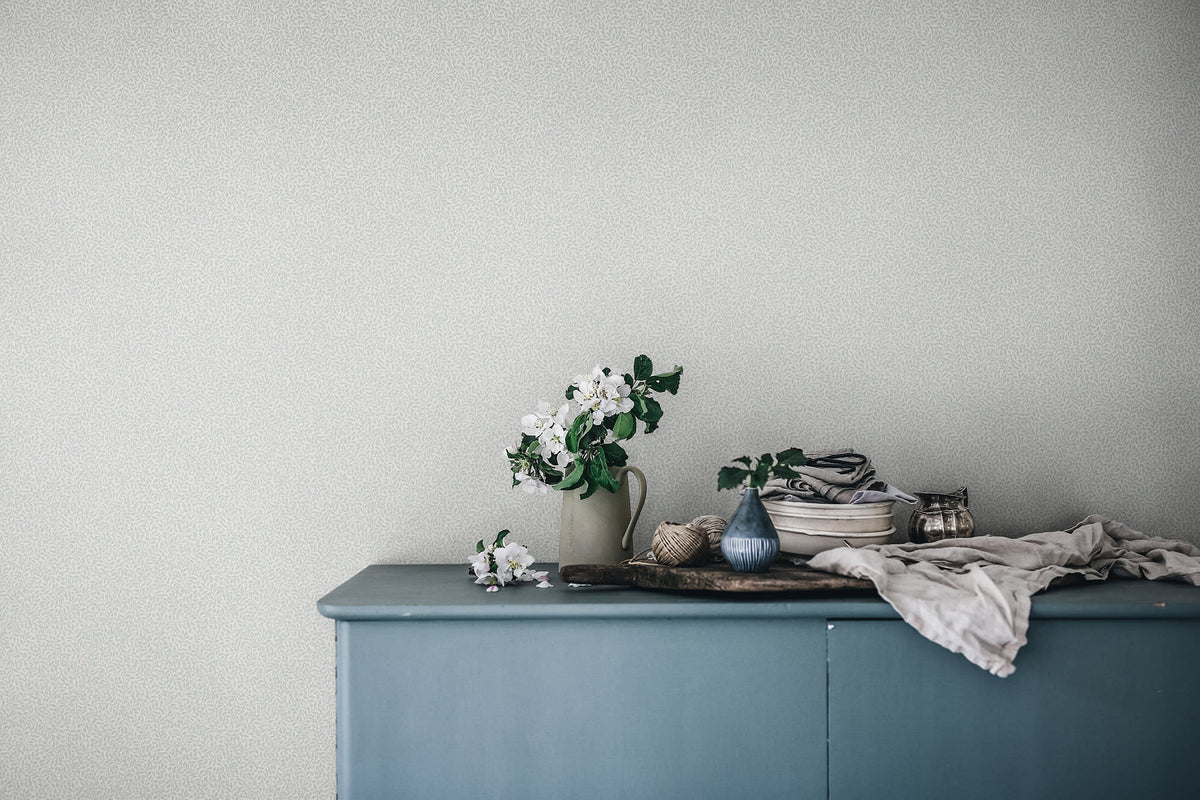 Bladverk wallpaper by Sandberg in Misty Blue, styled on an interior wall
