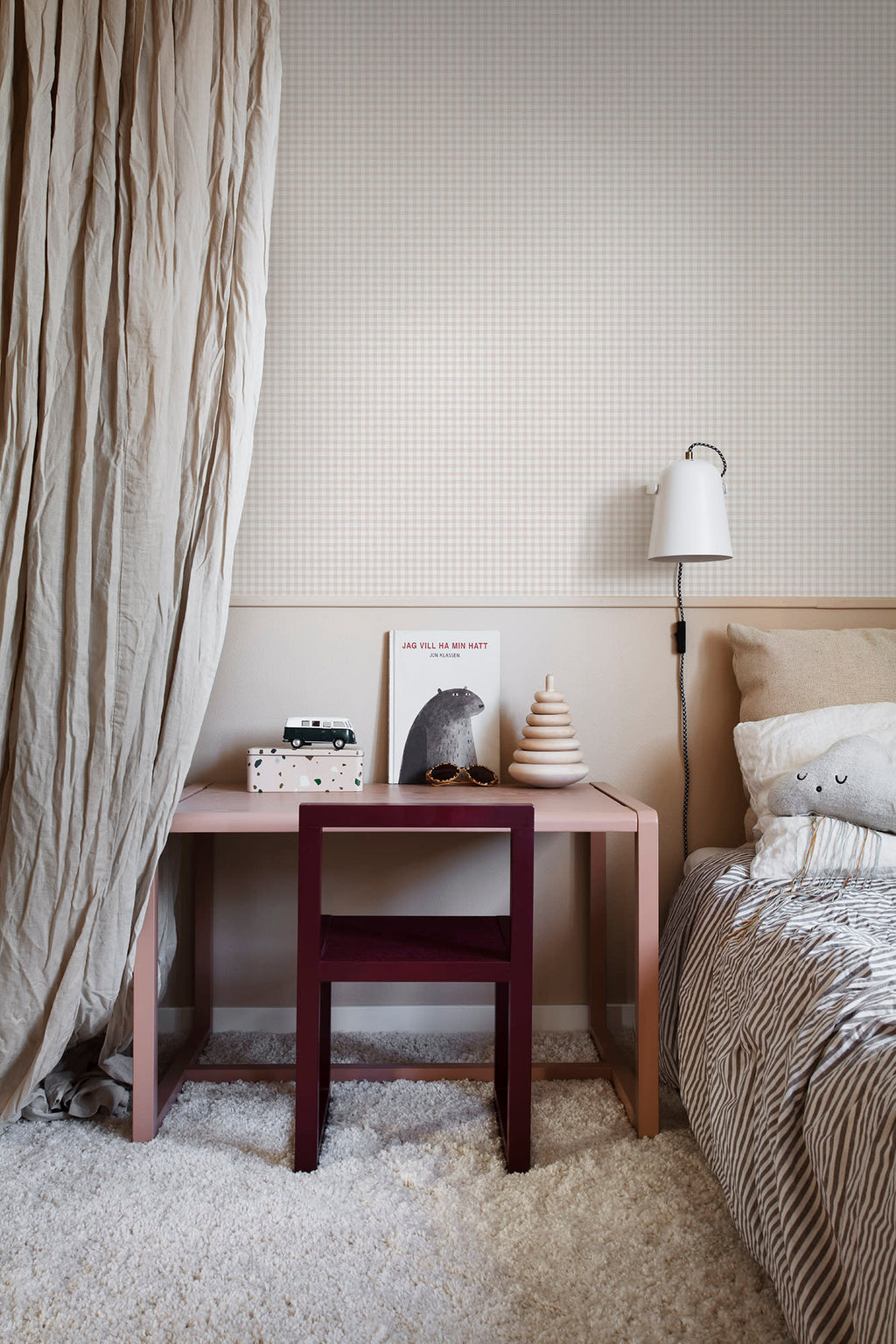 Ruta wallpaper by Sandberg in beige check in a child bedroom with a pink desk, burgundy chair and wall light