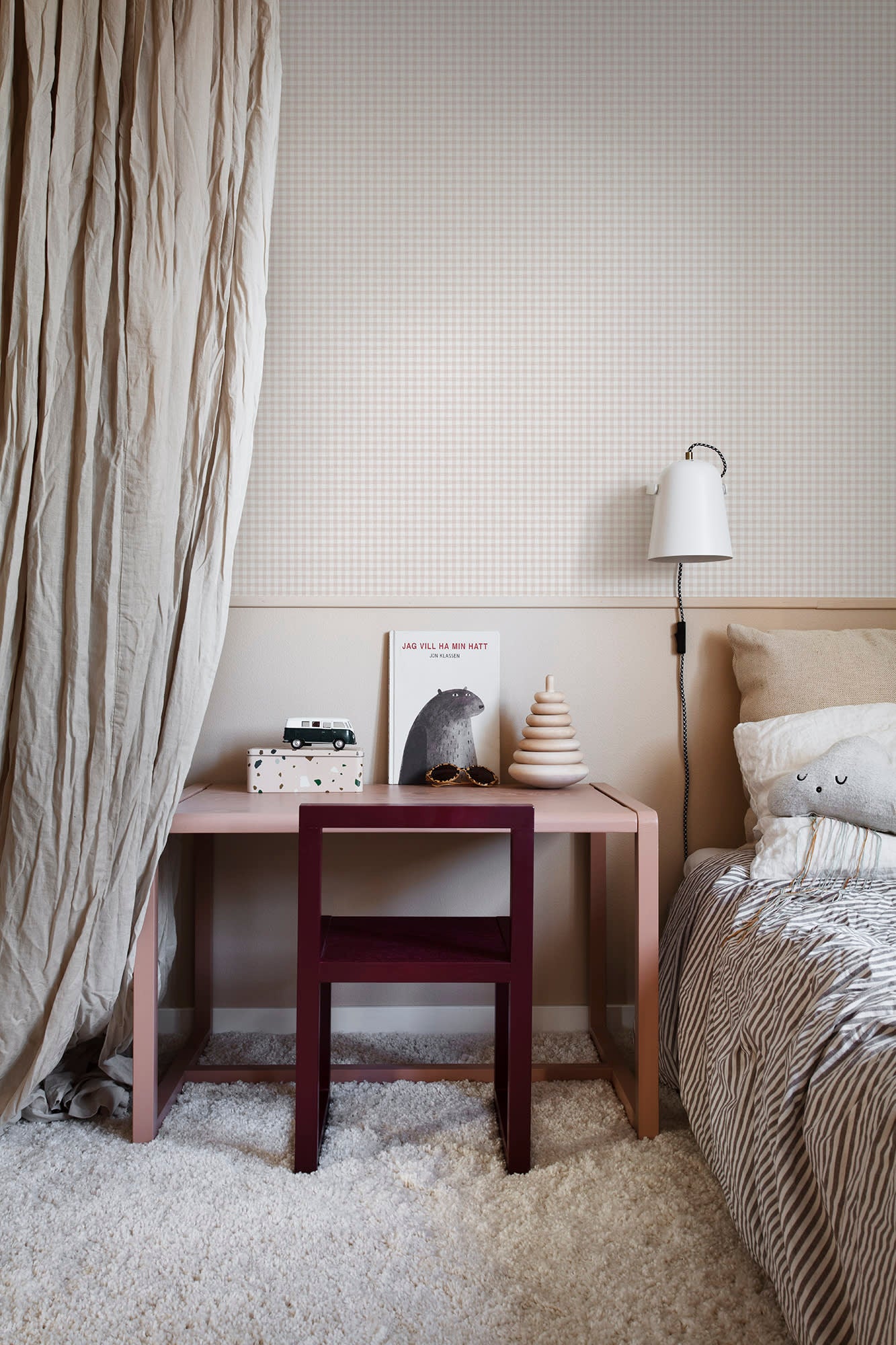 Ruta wallpaper by Sandberg in beige check in a child bedroom with a pink desk, burgundy chair and wall light