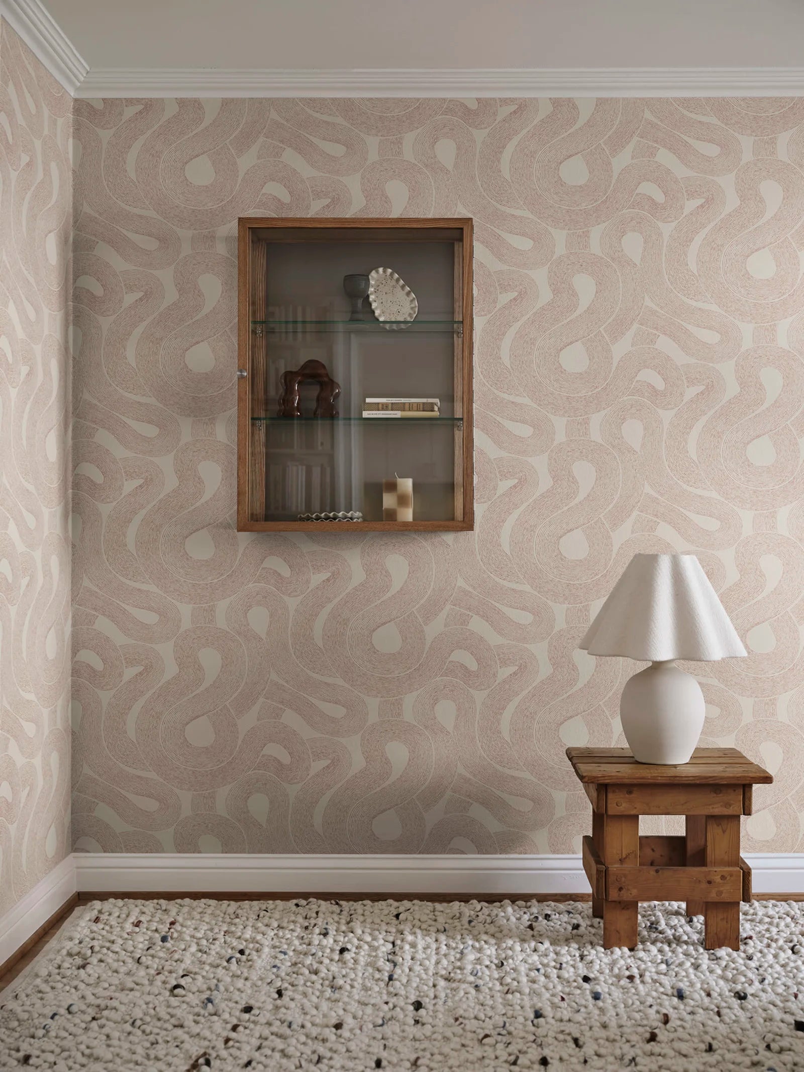 Zen wallpaper by Sandberg in warm beige looping print beside a wall display cabinet and rustic stool with lamp