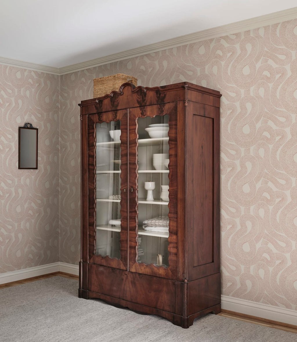 Zen wallpaper by Sandberg in soft beige looping print beside an antique glass-front cabinet of crockery